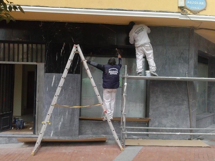 Dos trabajadores de Pavimentos Muriel realizando abrillantado de mármol en fachada