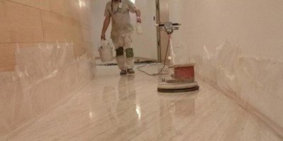 Profesional de Pavimentos Muriel realizando abrillantado de mármol en un pasillo interior
